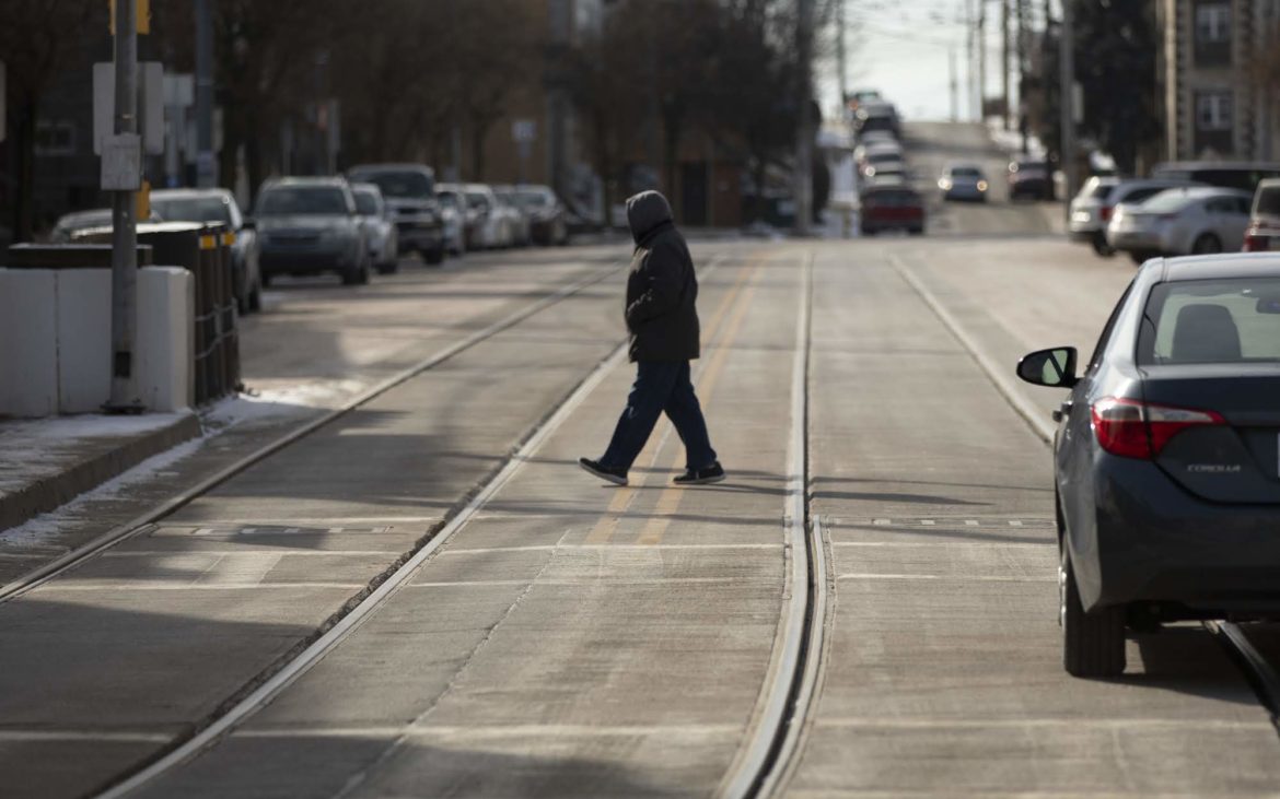 A pedestrian crosses the street in Beechview. (Photo by Kat Procyk/PublicSource)
