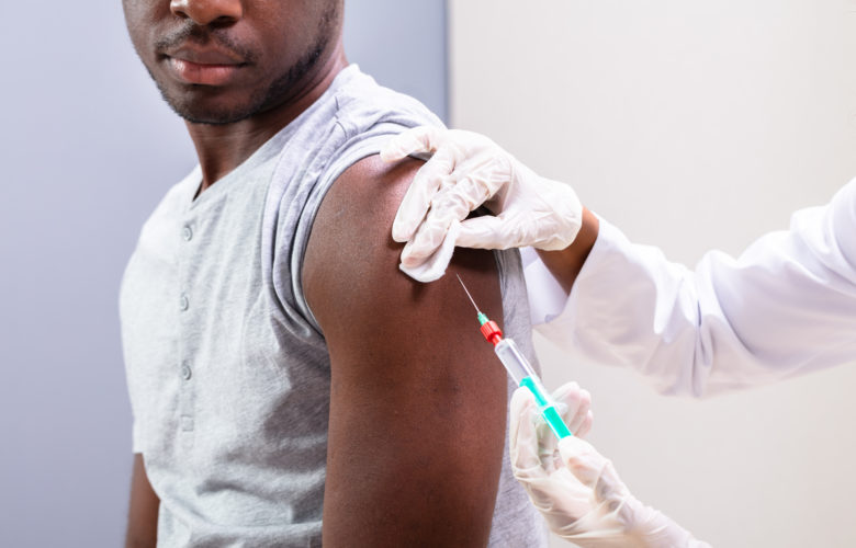 A Black patient receives a vaccine
