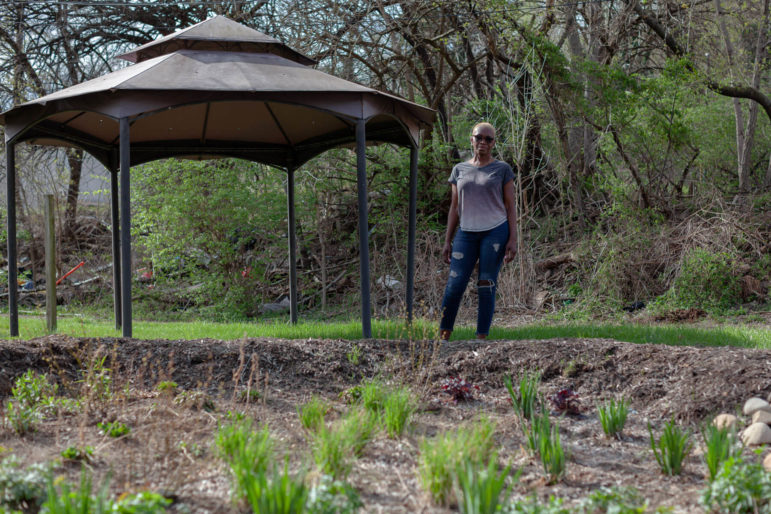 Betty Foster-Pinkley stands in front of a rain garden that Upstream, an environmental nonprofit, installed in her backyard. (Photo by Quinn Glabicki/PublicSource)