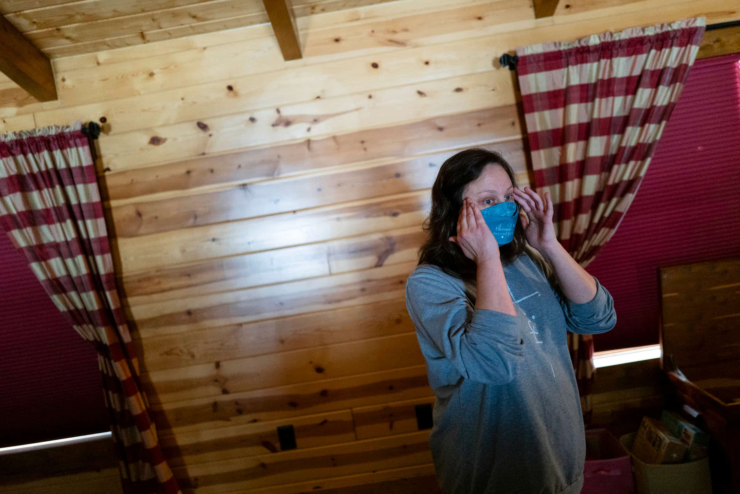 A woman wearing a face mask in a cabin.