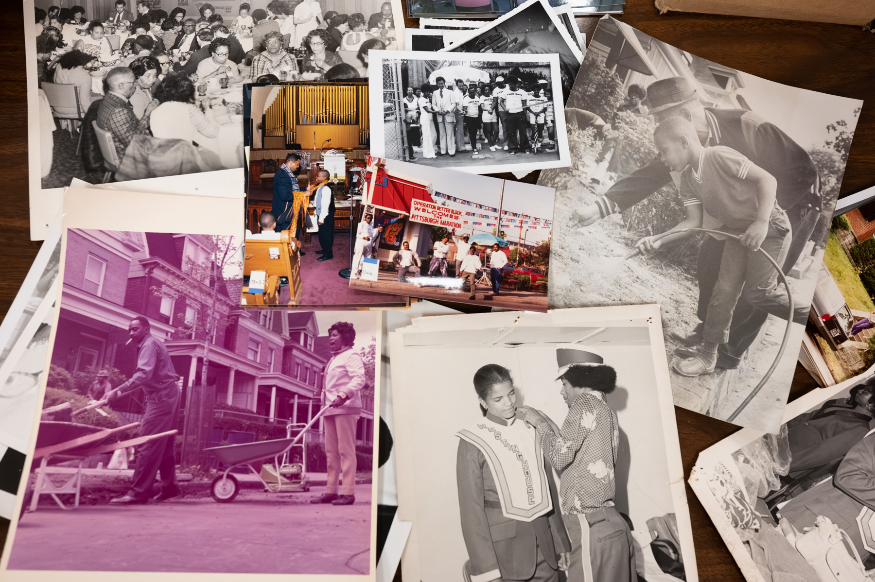 A collection of vintage and color photographs showing people in group gatherings, outdoor activities, and formal events spread out on a wooden surface.