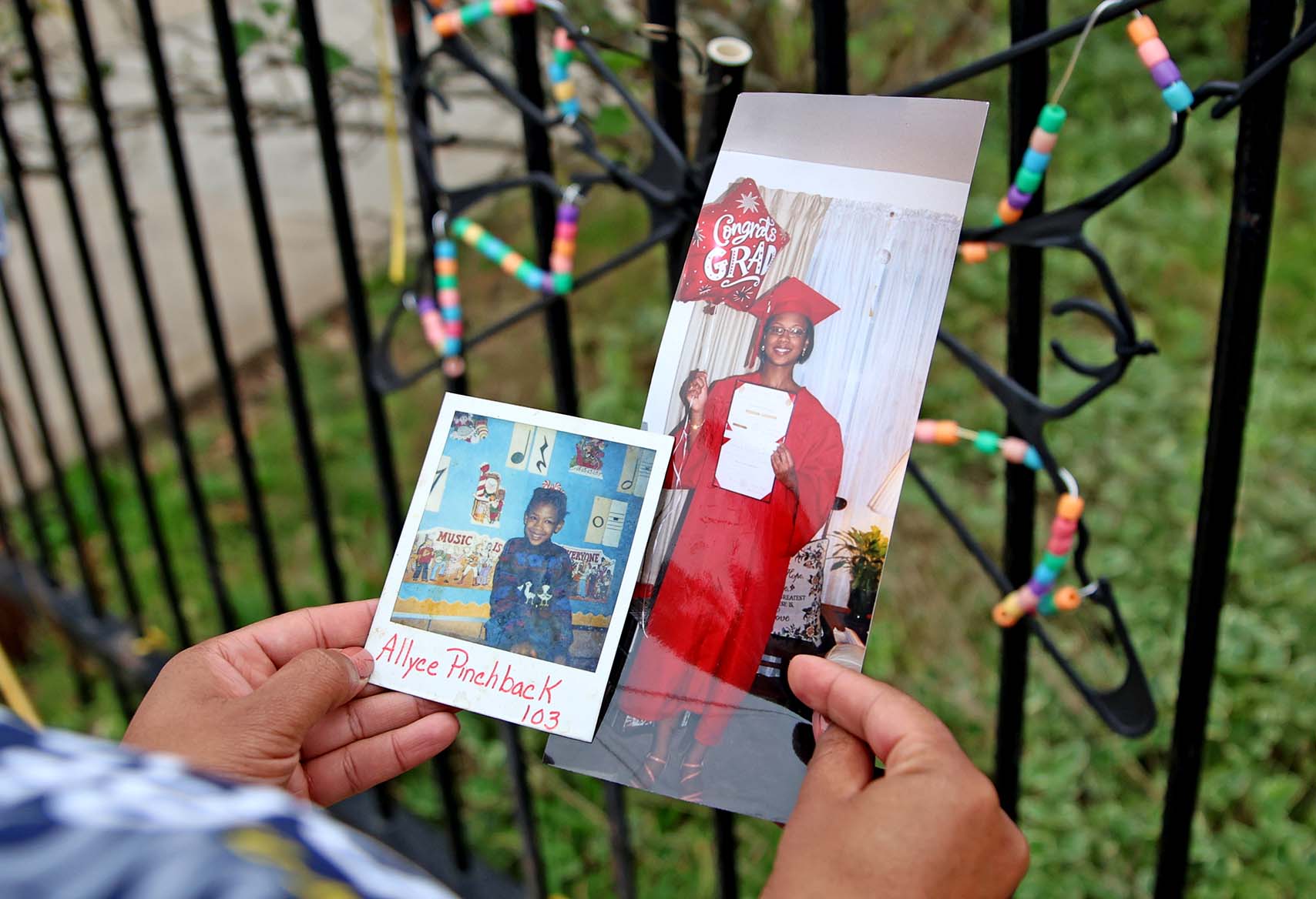 Hands holding a childhood photo of a girl and a photo of the same person in a graduation cap and gown, labeled “Allyee Pinchback 103”.